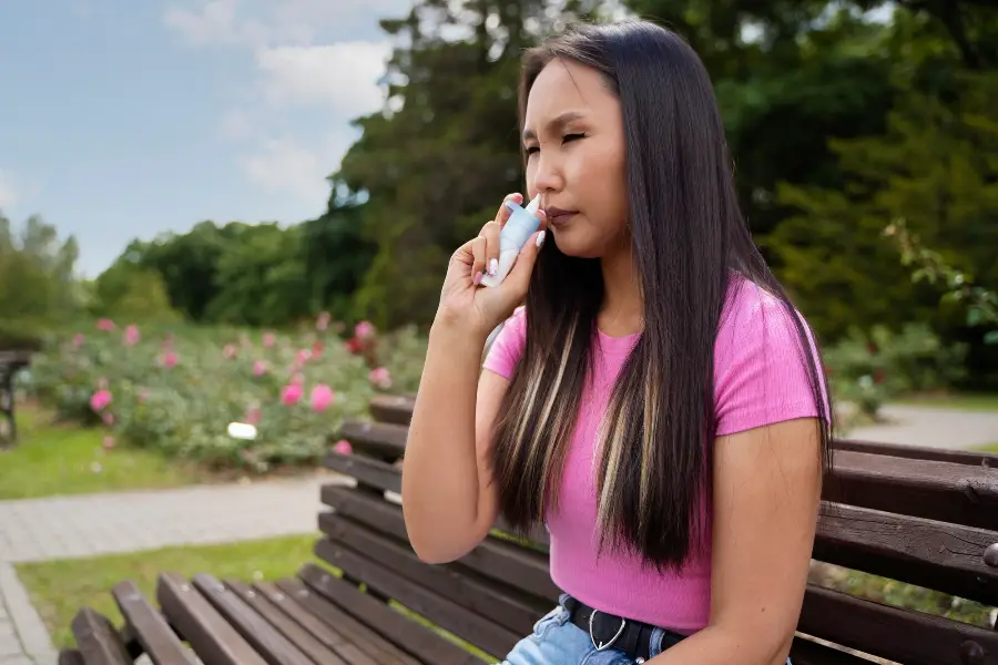 Side view woman using nasal spray